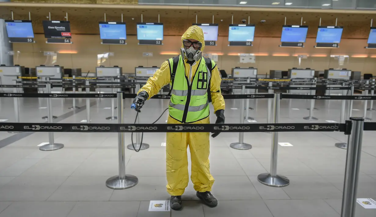 Seorang pekerja mendisinfeksi area check-in dalam Bandara Internasional El Dorado di Bogota, Kolombia, Senin (31/8/2020). Presiden Kolombia Ivan Duque mengizinkan lebih banyak penerbangan domestik mulai September. (Juan BARRETO/AFP)