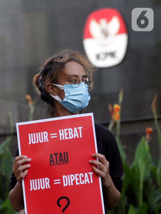 Peserta aksi dari Koalisi Masyarakat Sipil AntiKorupsi membawa poster saat berunjukrasa di depan Gedung KPK Jakarta, Selasa (18/5/2021). Dalam aksinya mereka memberi dukungan kepada 75 pegawai KPK yang dinyatakan tidak lulus TWK dalam tahap alih status kepegawaian. (Liputan6.com/Helmi Fithriansyah)