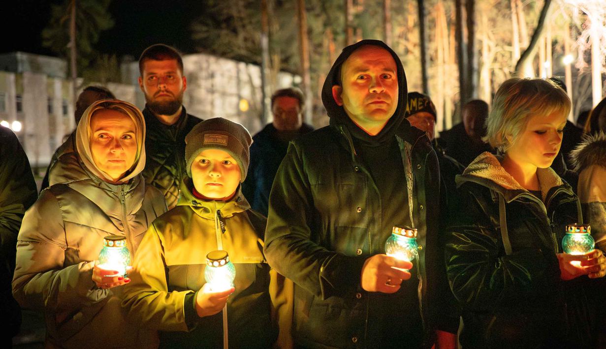 Orang-orang membawa lilin di tugu peringatan yang didedikasikan untuk petugas pemadam kebakaran dan pekerja yang meninggal setelah bencana nuklir Chernobyl, menjelang peringatan 40 tahunnya di Slavutych, Ukraina, Sabtu, 25 April 2026. (AP Photo/Dan Bashakov)