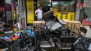 Seorang pria berdiri di dekat tumpukan kursi yang rusak di luar toko restorannya di Pasar Namseong yang bersejarah di distrik Gangnam Seoul (9/8/2022). Presiden Korea Selatan meminta agar jajarannya siap untuk melawan dampak lebih lanjut dari banjir di wilayah Seoul dan sekitarnya, seperti tanah longsor. (AFP/Anthony Wallace)