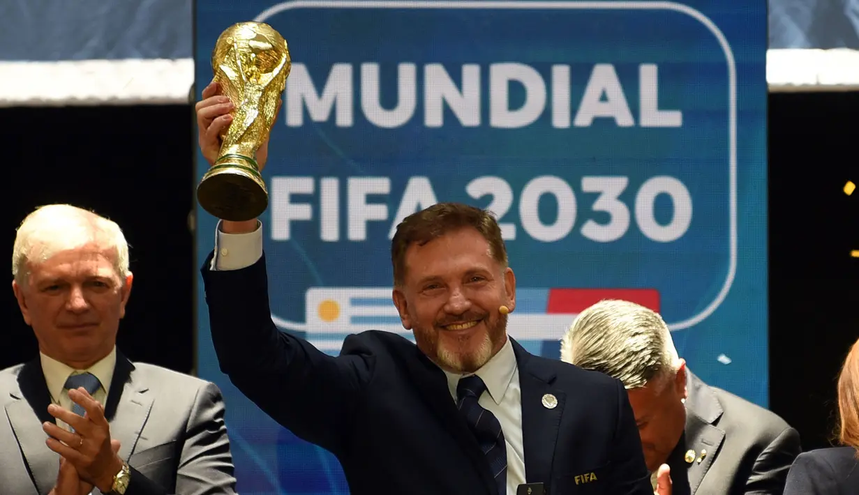 Presiden Paraguay, Alejandro Dominguez mengangkat replika trofi Piala Dunia saat penunjukkan Argentina, Paraguay, dan Uruguay sebagai negara tuan rumah Piala Dunia FIFA 2030 selama Kongres virtual FIFA di Luque, Paraguay pada 11 Desember 2024. (AFP/Daniel Duarte)