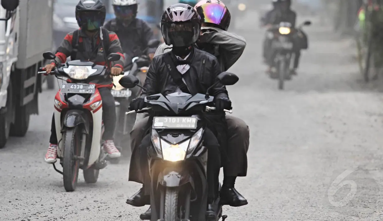 Pengendara melintasi jalan yang dipenuhi debu tebal di Jalan Kemukus, Tamansari, Jakarta Barat, Senin (24/11/2014). (Liputan6.com/Faizal Fanani)