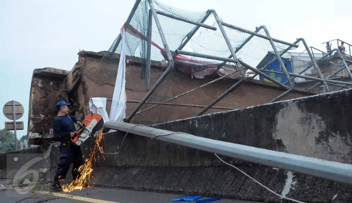 Petugas memotong besi saat evakuasi jembatan penyeberangan orang (JPO) yang roboh usai ditabrak truk trailer bermuatan crane di KM 7.600 Tol BSD, Tangsel, Senin (16/5). Evakuasi dilakukan dengan menggunakan dua unit mobil crane (Liputan6.com/Helmi Afandi)