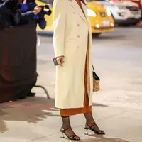 Katie Holmes mengenakan sweater dress sheer knit  dan jersey knit polo dress sambil menjinjing T Monogram, tas ransel kecil raffia. (Foto: Tory Burch)