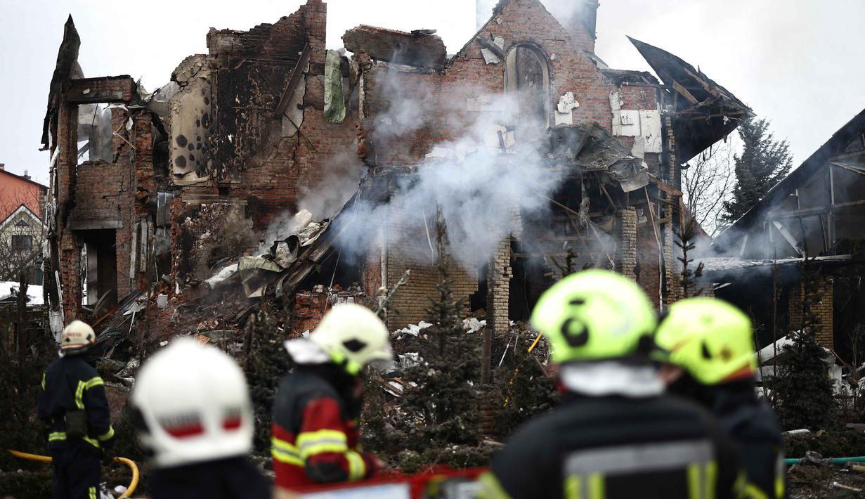 Para petugas penyelamat Ukraina berdiri di samping sebuah rumah yang rusak parah setelah serangan udara di Sofiivska Borshchagivka, wilayah Kyiv pada Minggu 22 Februari 2026. Rusia kembali melancarkan serangan besar-besaran menggunakan rudal dan pesawat nirawak (drone) ke wilayah pinggiran kota Kyiv. (Henry NICHOLLS/AFP)