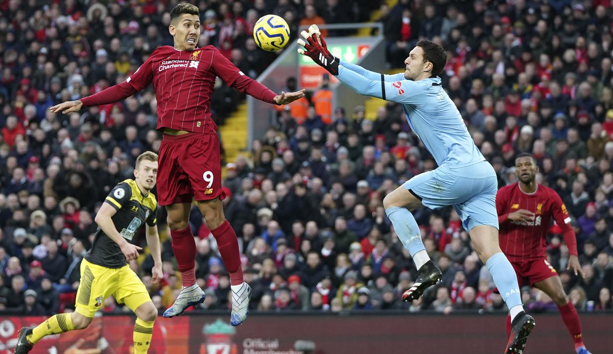 Kiper Southampton Alex McCarthy berusaha menangkap bola sundulan penyerang Liverpool, Roberto Firmino pada pertandingan Liga Inggris di Stadion Anfield, Sabtu (1/2/2020). Liverpool menang telak 4-0 atas Southampton. (AP Photo/Jon Super)