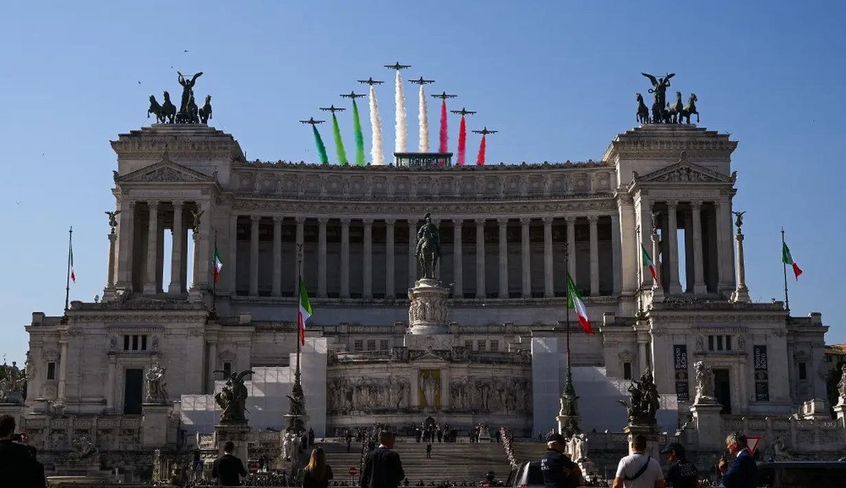 <p>Ini adalah momen atraksi pesawat dari angkatan udara Italia saat merayakan Hari Republik ke-76. Kepulan asap warna-warni menghiasi langit biru Roma. (VINCENZO PINTO/AFP)</p>
