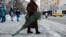Seorang wanita membawa pohon untuk perayaan Tahun Baru dari sebuah pasar di pusat kota Moskow, Rusia (27/12/2020). (Xinhua/Maxim Chernavsky)