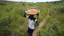 Beauty Waisoni, 46 tahun, yang tinggal di pinggiran ibu kota, Harare, biasanya bangun pada waktu fajar, mengemas ember plastik, keranjang, piring, dan pisau sebelum melakukan perjalanan ke hutan yang berjarak 15 kilometer (9 mil). (AP Photo/Tsvangirayi Mukwazhi)