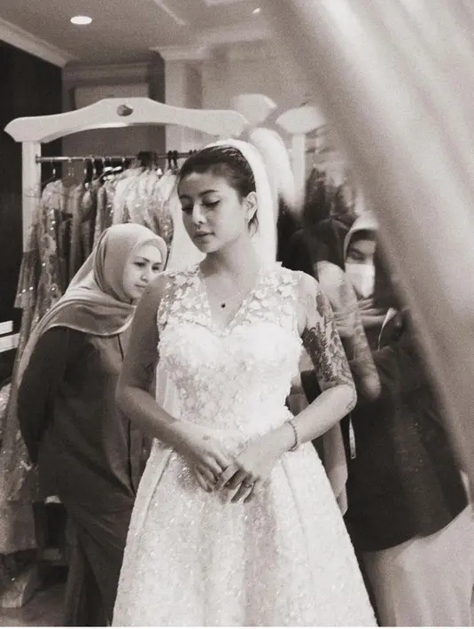 <p>Dalam foto hitam yang diunggah Awkarin, ia memerlihatkan sedang fitting gaun pengantin bersama sang desainer Asky Febrianti. [@narinkovilda]</p>