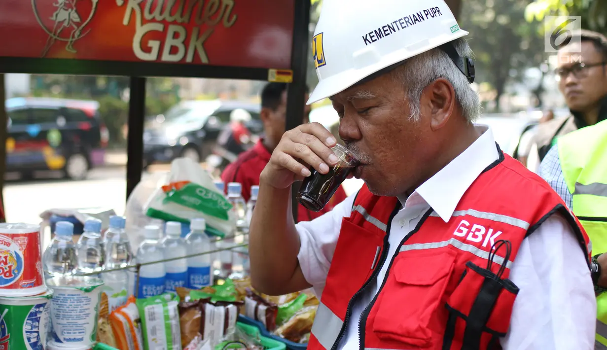 Menteri PUPR, Basuki Hadimuljono menikmati kopi yang dijajakan pedagang seusai meninjau renovasi stadion di Gelora Bung Karno (GBK), Jakarta, Kamis (10/5). Basuki meninjau kesiapan fasilitas dan prasarana untuk Asian Games 2018 (Liputan6.com/Angga Yuniar)