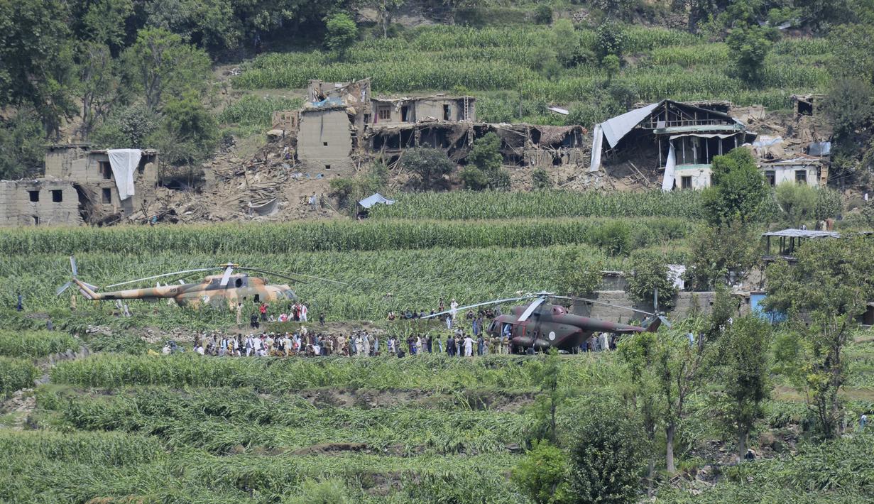 Warga setempat berkumpul di sekitar helikopter militer yang mendarat untuk memberikan bantuan dan mengevakuasi korban luka akibat gempa bumi yang menghancurkan desa-desa di Afghanistan timur, Mazar Dara, Provinsi Kunar, Afghanistan, Senin 1 September 2025. (AP Photo/Wahidullah Kakar)
