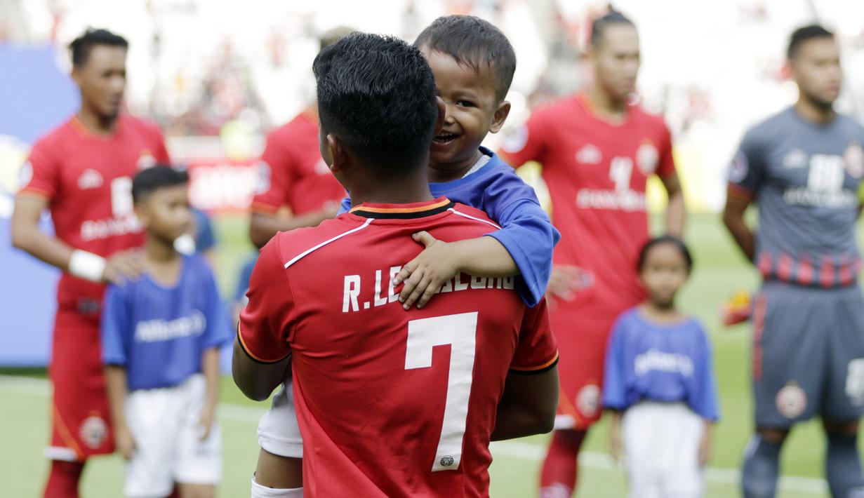 Seorang putra dari anggota The Jakmania digendong saat menjadi Player Escort Kids pada laga Piala AFC 2019 antara Persija Jakarta melawan Ceres Negros di SUGBK, Jakarta, Selasa (23/4). Kesempatan ini diberikan oleh Allianz. (Bola.com/Vitalis Yogi Trisna)