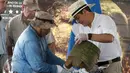 Presiden Honduras, Juan Orlando Hernandez (kanan) dan seorang arkeolog saat memamerkan benda kuno pada upacara di Catacamas, Honduras, (12/1). Benda - benda kuno ditemukan pada 2012 yang menyudut pada legenda "Kota Putih". (REUTERS / Jorge Cabrera