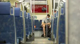 Seorang penumpang yang mengenakan masker menaiki kereta Go di Toronto, Kanada (21/7/2020). Mulai Selasa (21/7), para pelanggan layanan transportasi umum di Kanada, Go Transit, diwajibkan mengenakan masker atau penutup wajah. (Xinhua/Zou Zheng)