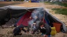 Anak-anak pengungsi yang melarikan diri bersama keluarga mereka dari serangan artileri Israel di Lebanon selatan membuat api unggun di samping tenda yang digunakan sebagai tempat berlindung di Beirut, Lebanon, Rabu, 1 April 2026. Di tengah meningkatnya serangan udara Israel, gelombang pengungsi di Lebanon terus bertambah. (AP Photo/Emilio Morenatti)