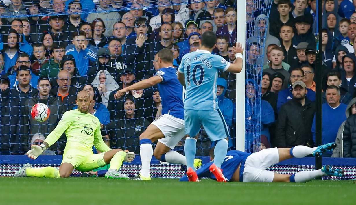 Kiper Everton Tim Howard (kiri) menepis bola tendangan Sergio Aguero pada pertandingan Liga Premier Inggris di Stadion Goodison Park, Inggris, Minggu (24/8/2015). The Citizens pun kini kokoh di puncak klasemen. (Reuters/Jason Cairnduff)