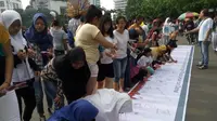 Sejumlah warga Ibu Kota yang menamakan diri Forum Warga Jakarta Cinta Damai, menggelar aksi ‎sejuta tanda tangan warga DKI. (Liputan6.com/Taufiqurrohman)