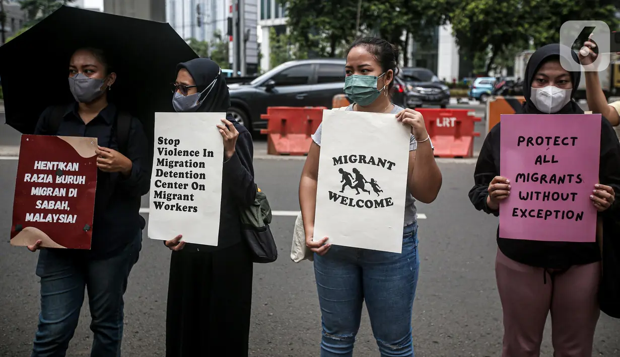 Sejumlah buruh migran membawa poster saat menggelar aksi di depan Kedutaan Besar Malaysia, Jakarta, Selasa (9/8/2022). Mereka menuntut pemerintah Malaysia melakukan perbaikan dan menghentikan berbagai praktik kejam di dalam pusat tahanan imigrasi. (Liputan6.com/Faizal Fanani)