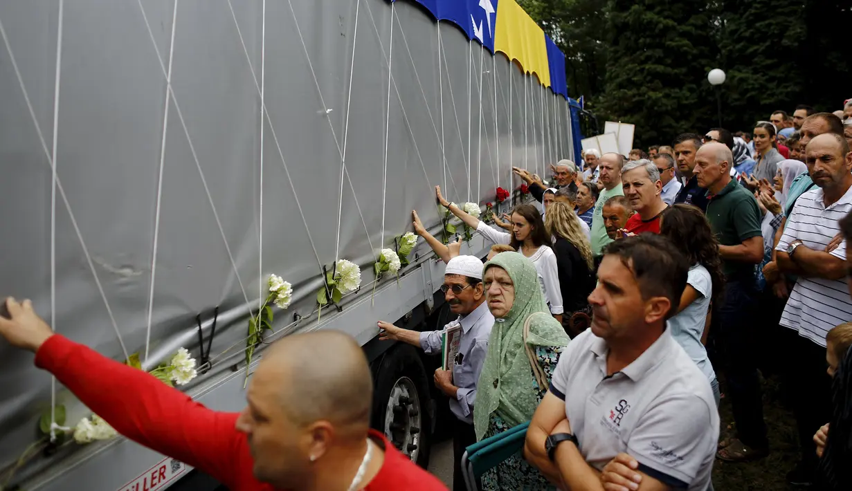 Warga menyentuh truk yang membawa 136 peti korban pembantaian Srebrenica pada Juli 1995, di desa Visoko , Bosnia-Herzegovina, Kamis, (9/7/2015). Ribuan orang tewas dan menjadi yang terburuk di Eropa sejak Perang Dunia II. (REUTERS/Stoyan Nenov)