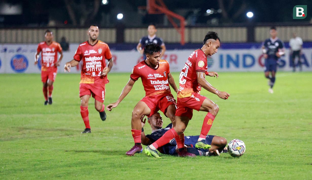 Pemain Bali United, Novri Setiawan dan Rahmat Reski, menghentikan pergerakan pemain Arema FC, Gian Zola, saat pertandingan Liga 1 BRI di Stadion PTIK, Jakarta, Senin (27/3/2023).  Arema menang dengan skor 3-1.  (Bola.com/M Iqbal Ichsan)