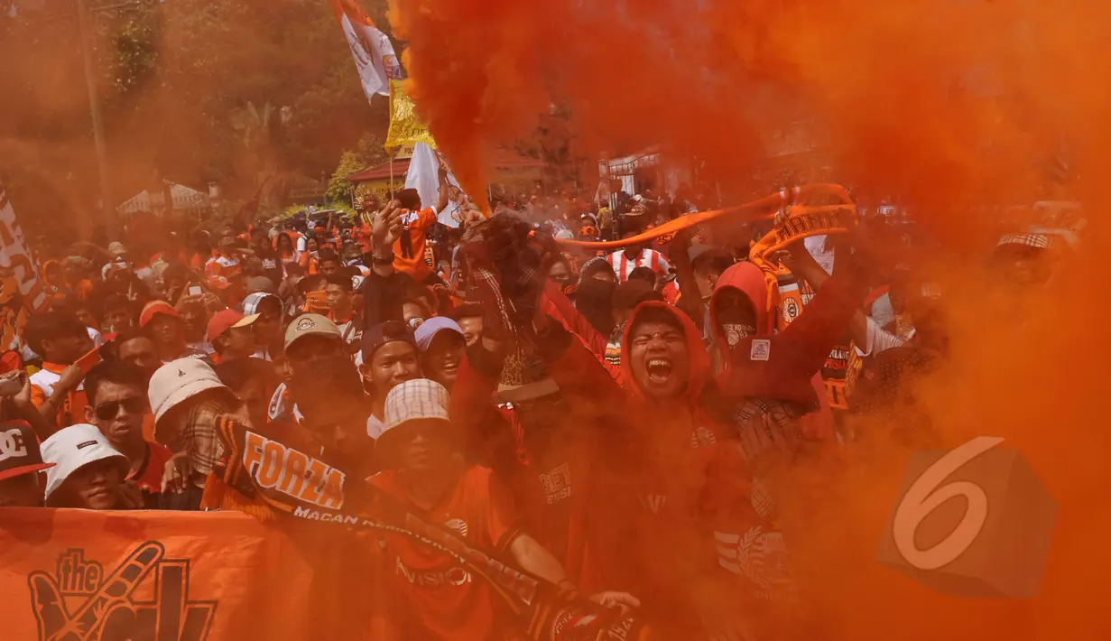 Puluhan ribu Jakmania (suporter tim Persija) menggelar aksi di depan Istana Negara, Jakarta, Selasa (5/5/2015). Dalam aksinya, mereka mengeluarkan bom asap berwarna orange sebagaimana warna kostum tim Persija Jakarta. (Liputan6.com/Johan Tallo)