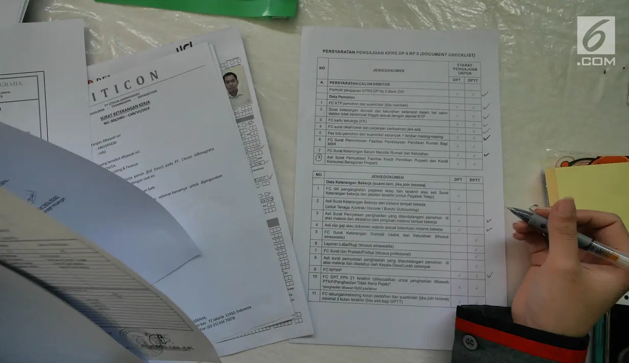 Petugas mengecek data fomulir pendaftaran Program Samawa Rumah DP 0 Rupiah di lokasi Rusunami Klapa Village, Jakarta, Minggu (28/7/2019). Proses pengajuan Program Samawa Rumah DP 0 rupiah dimulai Sabtu (27/7/2019) sampai 4 Agustus 2019. (Liputan6.com/Herman Zakharia)