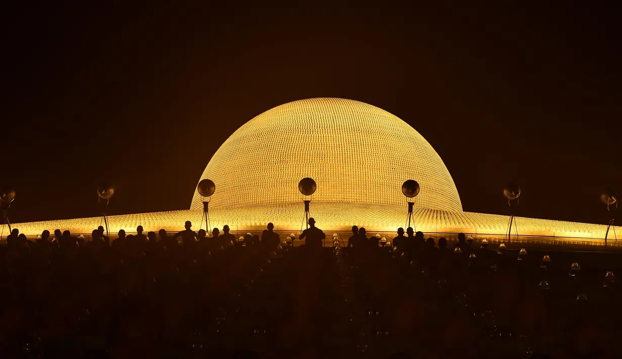 Sejumlah biksu bersiap untuk melakukan ritual Makha Bucha Day di kuil Wat Dhammakaya, Bangkok, Thailand (11/2). Makha Bucha atau Magha Puja berarti puja/peringatan yang berhubungan dengan bulan Magha. (AFP/Lillian Suwanrumpha)