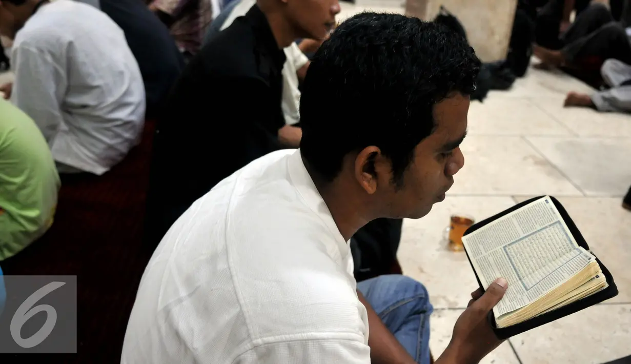 Sejumlah warga tampak membaca Alquran saat menunggu waktu berbuka puasa di Masjid Istiqlal, Jakarta (22/6/2015). Sekitar 3000 kotak makanan dan minuman dibagikan setiap harinya selama bulan Ramadan. (Liputan6.com/JohanTallo)