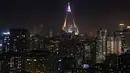 Pemandangan saat puncak hotel Ryugyong dihiasi bendera Korea Utara di kota Pyongyang, Korea Utara (9/4). (AFP Photo/Ed Jones)