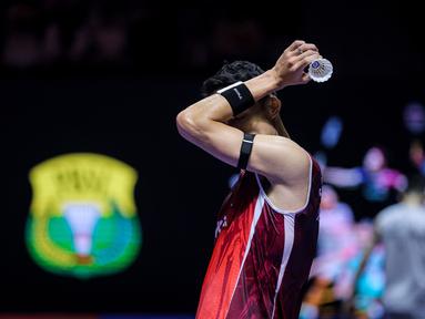 Pebulu tangkis tunggal putra Indonesia, Jonatan Christie menyeka keringatnya dalam laga 32 besar Indonesia Open 2025 saat melawan wakil Singapura, Jia Heng Jason Teh di Istora Senayan, Jakarta, Selasa (03/06/2025). (Bola.com/Bagaskara Lazuardi)