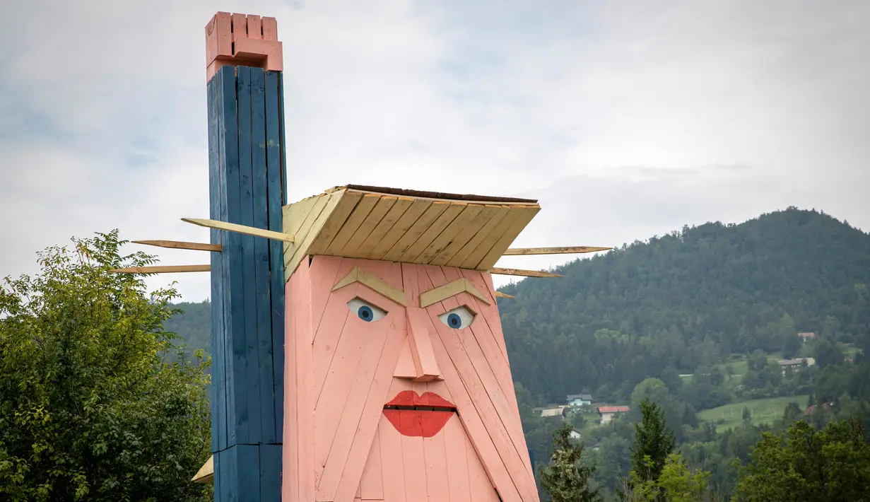 Sebuah patung kayu yang menyerupai Donald Trump didirikan di Sela pri Kamniku, kawasan utara Slovenia, 30 Agustus 2019. Patung Trump setinggi 8 meteritu mengenakan setelan biru, kemeja berwarna putih, dasi merah, serta mengangkat tangan seperti Patung Liberty. (AP/Darko Bandic)
