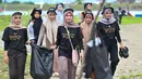Para duta wisata Agam-Inong (laki-perempuan) saat membersihkan sampah plastik dan sampah lainnya yang terdampar di pantai selama kampanye di sebuah pantai di Banda Aceh pada 29 Oktober 2023. (CHAIDEER MAHYUDDIN/AFP)