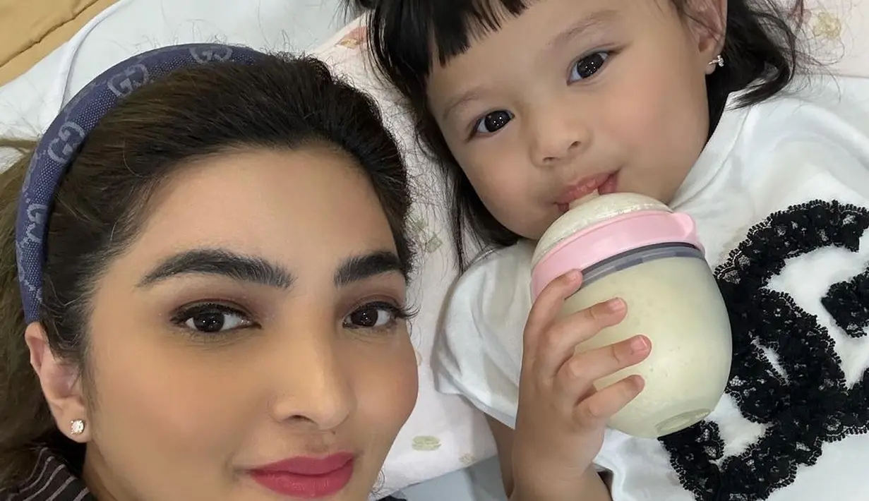 Di foto lainnya, Ashanty berfoto selfie dengan Ameena. Gemas, Ameena terlihat sedang minum susu dari botol dotnya, Ashanty tampil cantik dengan atasan berkerah bernuansa hitam dan bermotif garis. Ashanty juga menambahkan bando denim untuk merapikan rambutnya. [Foto: Instagram/ashanty_ash]