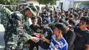Pihak pemerintah bahwa menyebut cadangan pangan di wilayah itu mencukupi, namun terkendala masalah distribusi akibat akses jalan terputus. Tampak dalam foto, warga desa antre untuk menerima bahan pangan pokok gratis yang didistribusikan di tengah upaya bantuan dari gudang beras pemerintah di Sarudik, Tapanuli Tengah, Provinsi Sumatra Utara, pada Rabu 3 Desember 2025. (YT Hariono/AFP)