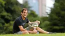 Petenis Swiss, Roger Federer berpose dengan Piala Challenge Norman Brookes di Government House, Melbourne, Australia (29/1). Federer mengalahkan petenis Kroasia Marin Cilic 6-2, 6-7(5), 6-3, 3-6, 6-1. (AP Photo/Ng Han Guan)
