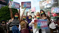 Dipimpin oleh waria dan DJ yang membunyikan musik upbeat, lusinan juru kampanye LGBT dan pendukung undang-undang tersebut mengenakan masker berwarna pelangi dan menari di depan persimpangan Shibuya yang terkenal di ibu kota Jepang. (Foto: AFP/Philip Fong)