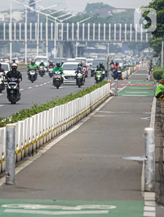 Kendaraan melintas di samping jalur khusus sepeda yang diberikan pembatas jalur permanen di Jalan Sudirman, Jakarta, Kamis (17/6/2021). Kapolri Jenderal Listyo Sigit Prabowo akan membongkar jalur sepeda di Sudirman-Thamrin dan mempelajari jalur sepeda di negara lain. (Liputan6.com/Faizal Fanani)