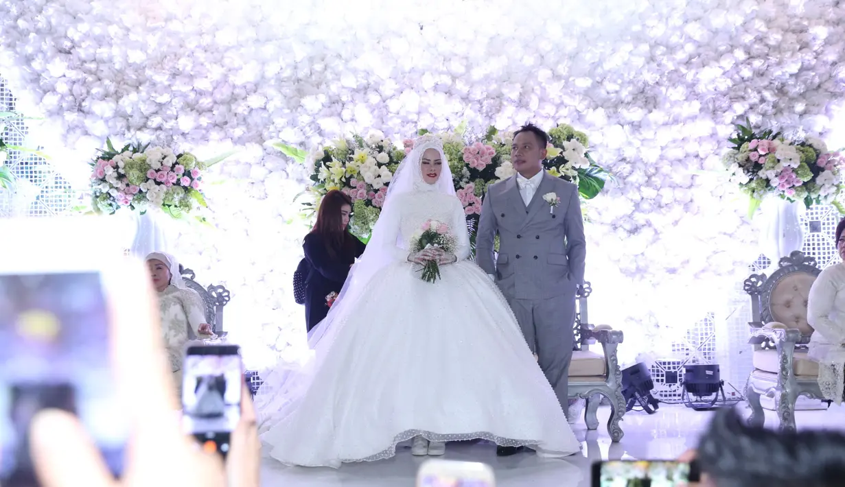 Angel Lelga tampil cantik dan angun dengan busana putih yang dikenakan. Sedangkan pengantin pria tampak gagah dengan setelan jas warna abu-abu. (Nurwahyunan/Bintang.com)