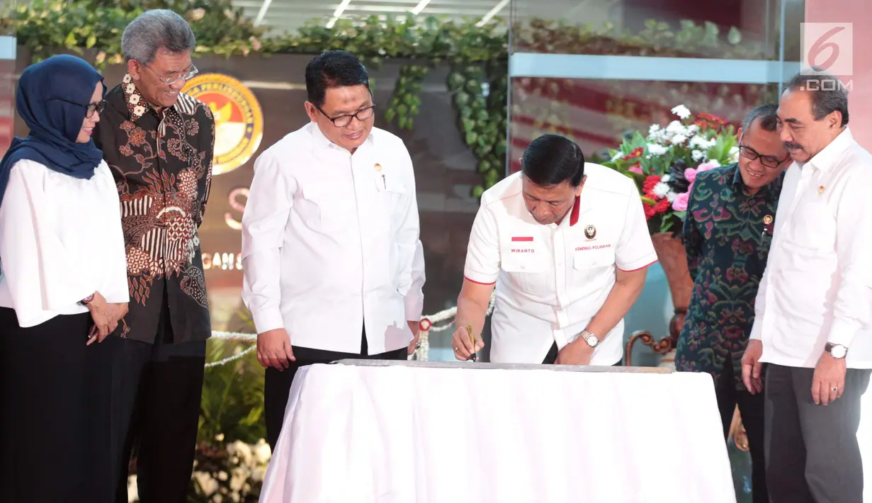 Menko Polhukam Wiranto didampingi Ketua LPSK Abdul Haris Semendawai menandatangani berkas saat memberi kompensasi kepada sejumlah perwakilan korban terorisme di Kantor LPSK, Jakarta, Kamis (6/9). (Liputan6.com/Faizal Fanani)