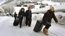 Sejumlah turis menuju heliport untuk dievakuasi dari Zermatt di Swiss (10/1). Pemadaman listrik di beberapa daerah lain, seperti di Kota Valais, juga terjadi akibat hujan salju lebat. (AFP Photo/Mark Ralston)