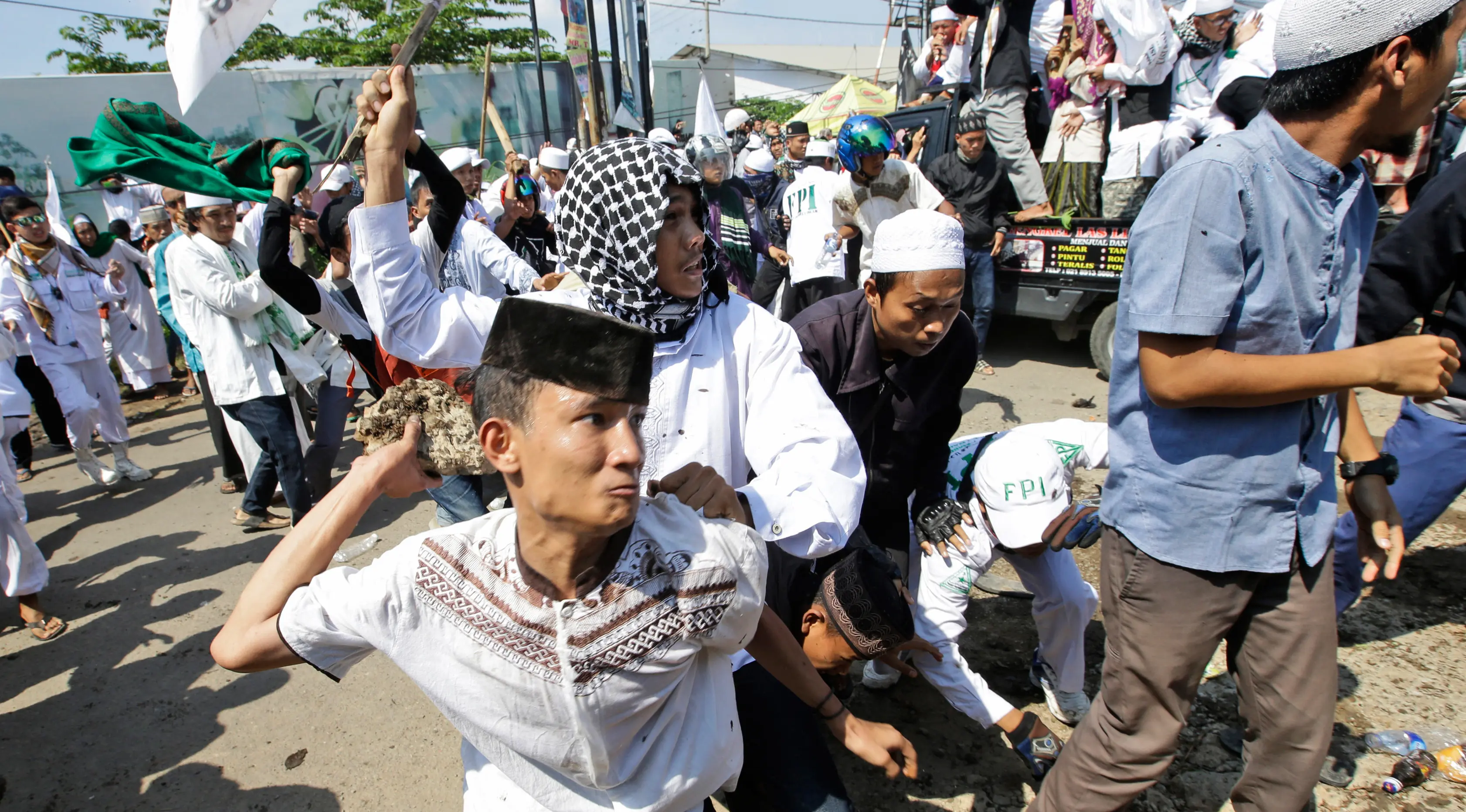 Massa saat terlibat bentrok dengan aparat kepolisian di depan Gereja Katolik Santa Clara, Bekasi, Jawa Barat (24/3). Aksi bentrokan tersebut membuat sejumlah aparat kepolisian dan pemuda Ormas Islam terluka. (AP Photo/Achmad Ibrahim)