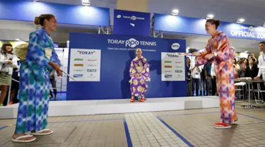 Petenis Monica Puig dan Agnieszka Radwanska bermain permainan tradisional Jepang yang disebut 'hagoita' disela turnamen tenis Pan Pacific Terbuka di Ariake Coliseum, Tokyo, Jepang, (20/9). (REUTERS/Issei Kato)