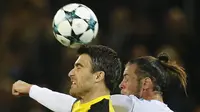 Gelandang Real Madrid, Gareth Bale, duel udara dengan bek Dortmund Sokratis Papastathopoulos, pada laga Liga Champions di Stadion Signal Iduna Park, Dortmund, Selasa (26/9/2017). Dortmund kalah 1-3 dari Madrid. (AP/Michael Probst)