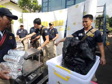Petugas Bea Cukai menjaga barang bukti sabu seberat 33 kg saat rilis di Jakarta, Kamis (23/6). Bea Cukai bersama BNN menggagalkan penyelundupan 33 kg sabu yang dikemas dalam tiga moulding stainless stell. (Liputan6.com/Helmi Fithriansyah)
