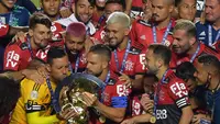 Kapten tim Flamengo Diego (kiri) mencium trofi disaksikan rekan satu timnya usai menjuarai Liga Brasil di Sao Paulo, Kamis (25/2/2021). (Foto: AFP/Nelson Almeida)