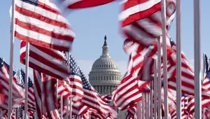 Capitol AS terlihat di antara bendera-bendera yang ditempatkan di National Mall menjelang pelantikan Presiden terpilih Joe Biden di Washington, Senin (18/1/2021). Acara pengambilan sumpah Joe Biden  akan berada dalam situasi berbeda dari pelantikan-pelantikan sebelumnya. (AP Photo/Alex Brandon)