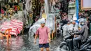 Seorang pria berjalan melewati banjir di tengah hujan deras yang tiba-tiba mengguyur di sebuah pasar dekorasi Natal di Manila, Filipina (9/12/2020). (Xinhua/Rouelle Umali)