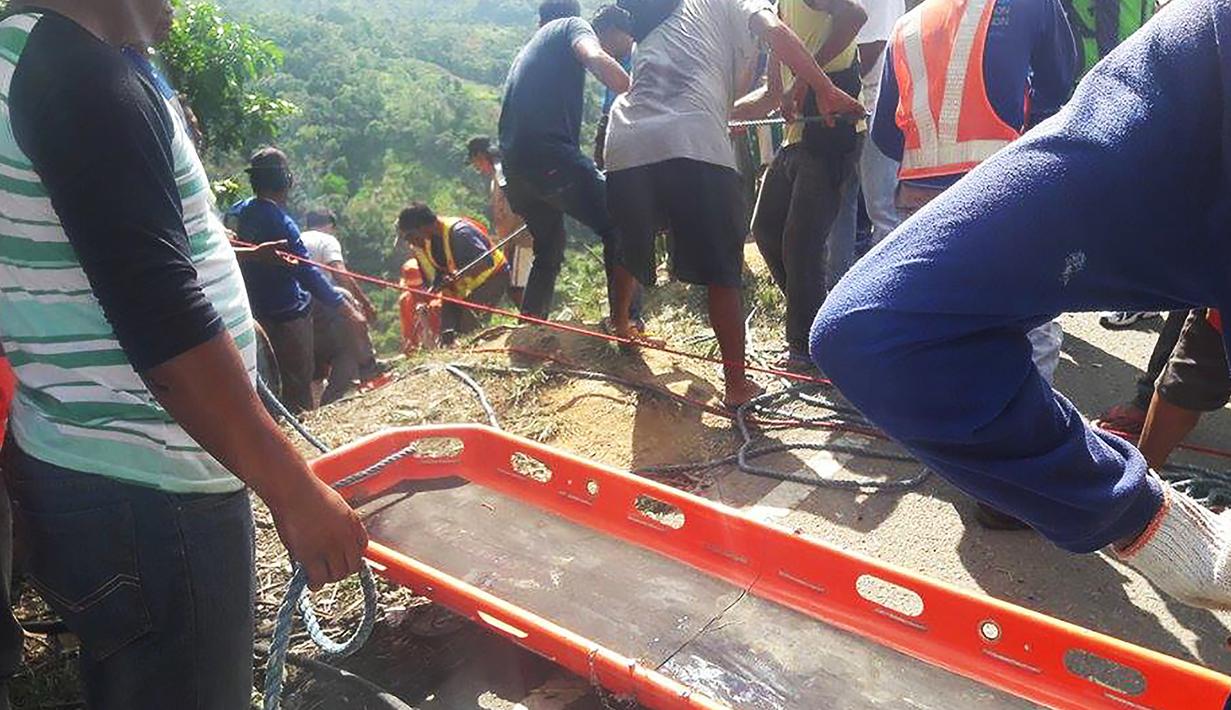 Petugas penyelamat menggunakan tandu untuk mengevakuasi penumpang bus yang terjun ke jurang di Kota Carranglan, Provinsi Nueva Ecija di Filipina Utara, Selasa (18/4). Bus terjun ke dalam jurang sedalam 24 meter di kawasan pegunungan. (Handout/MDRRMO/AFP)