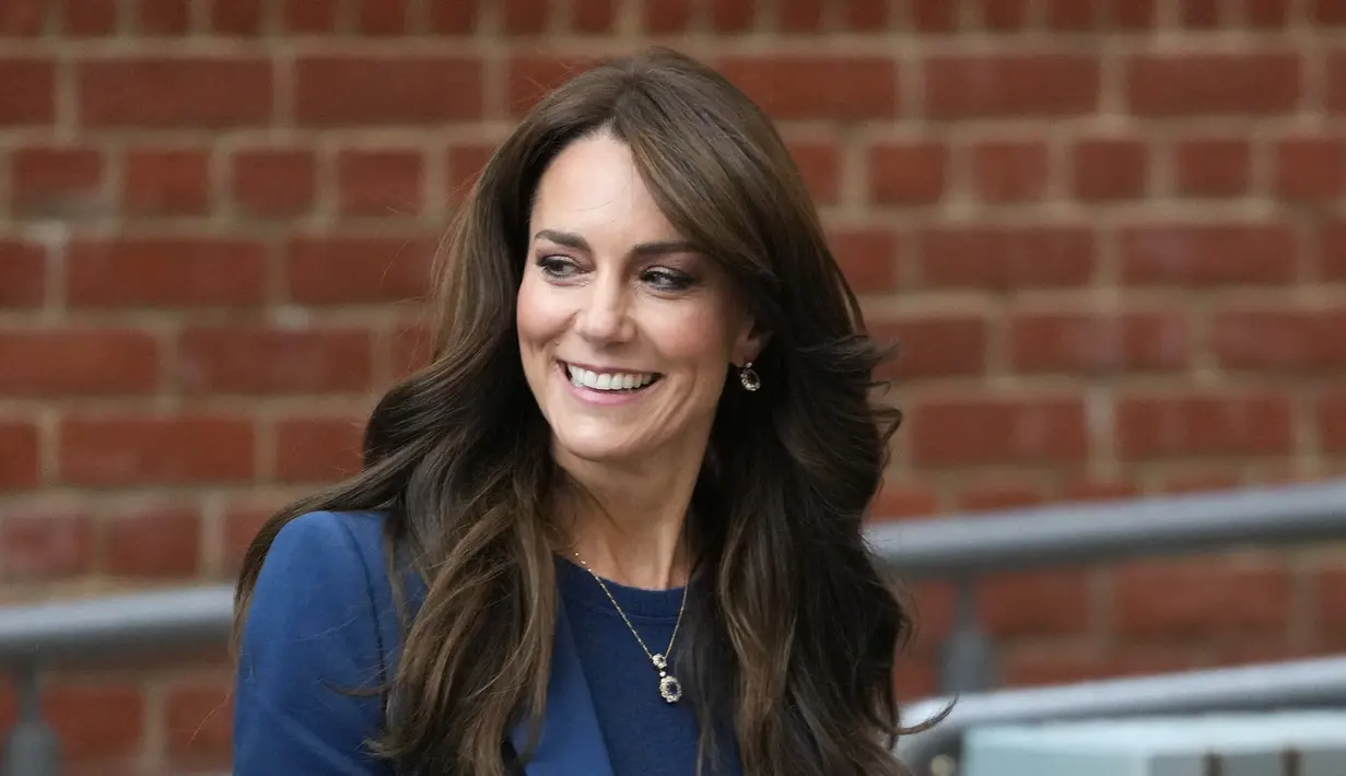 <p>Perempuan cantik berambut cokelat ini menyempurnakan penampilannya dengan ikat pinggang kulit hitam dengan hiasan emas dan sepatu hak stiletto. (AP Photo/Kirsty Wigglesworth)</p>
